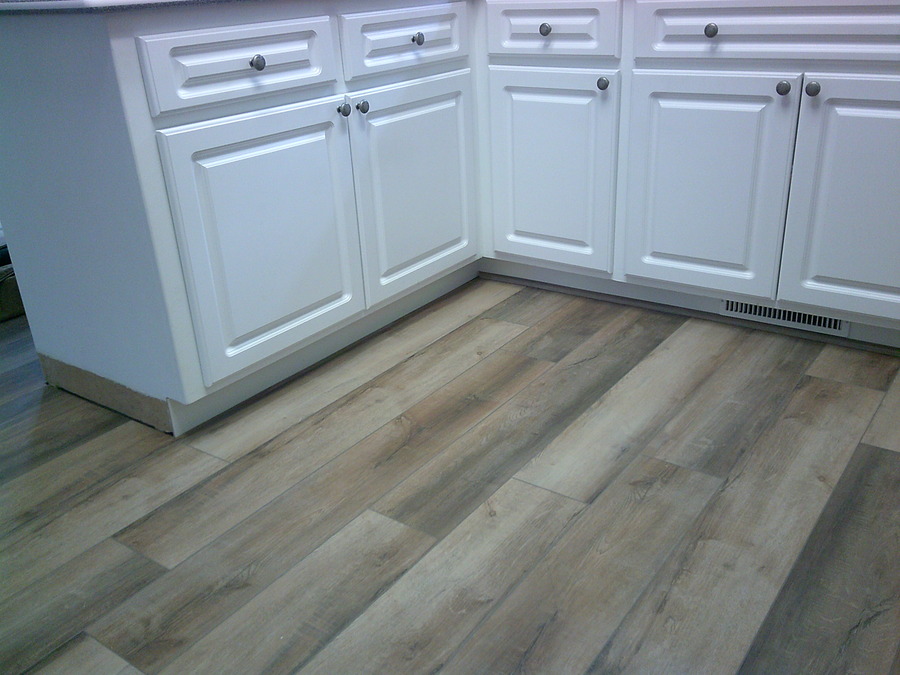 Kitchen with newly installed wood look luxury vinyl flooring.