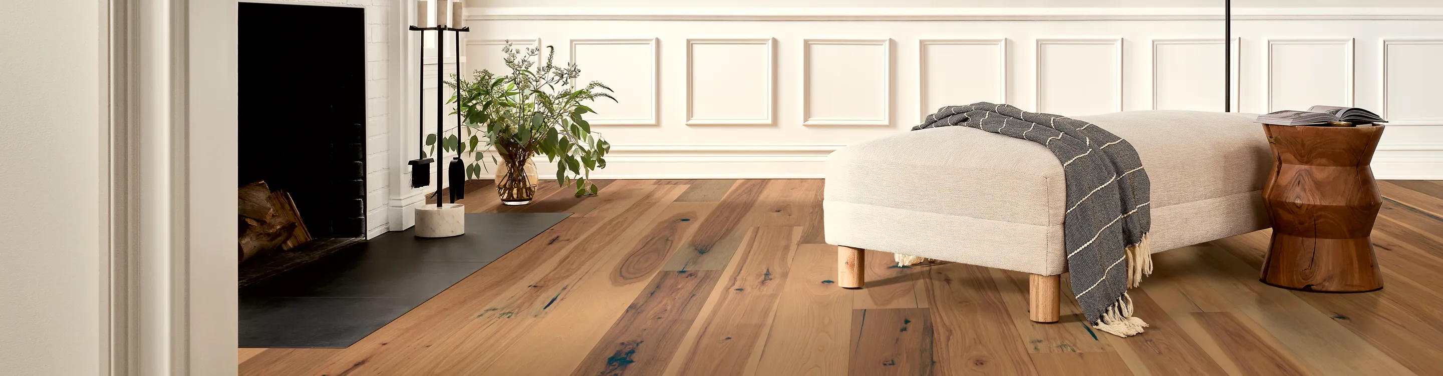 light hardwood flooring in living area with chaise lounge and fireplace